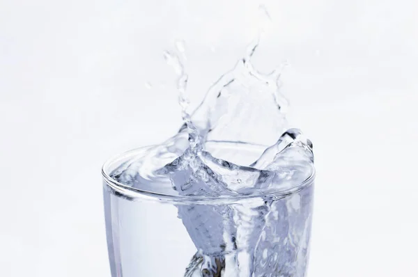 water splashing into glass splash on white background