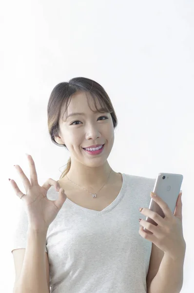 Retrato Mulher Jovem Usando Telefone Celular Mostrando Sinal Isolado Fundo — Fotografia de Stock
