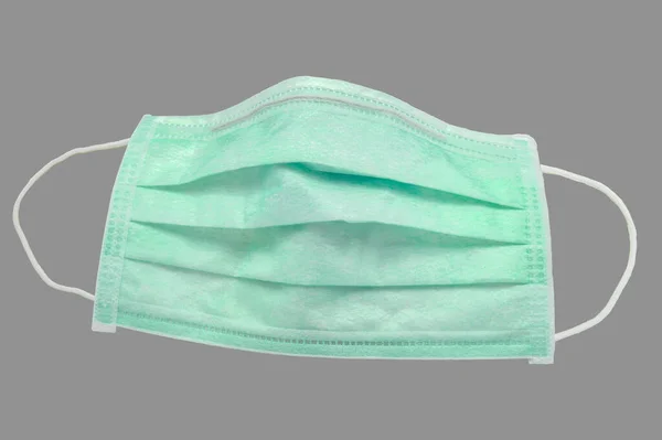 Used green 3 ply disposable surgical mask isolated on gray background, with clipping path