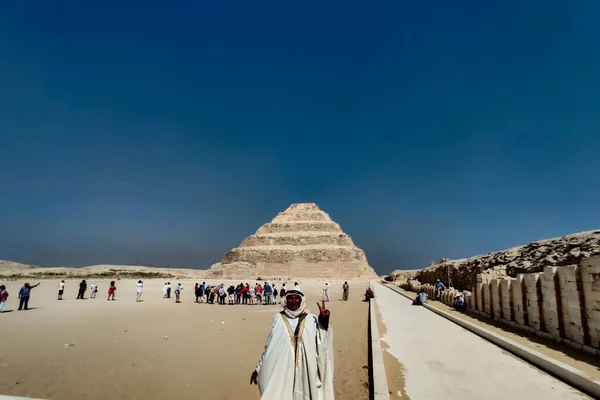 エジプトのドシエのピラミッドやステップピラミッドの前にポーズをとる地元の男 — ストック写真