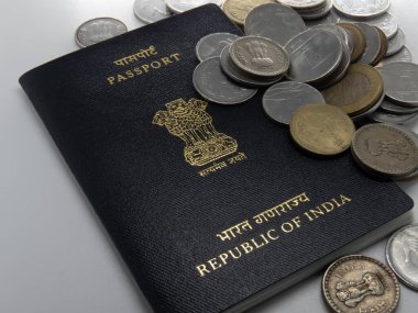 Beyaz masada üzerinde rupi olan Hint pasaportu resmi.