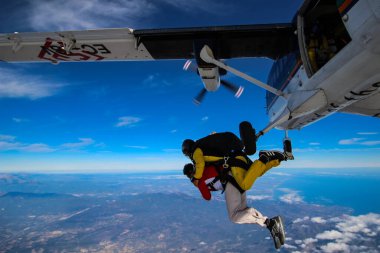 Gökyüzünde paraşütle atlayan adam.