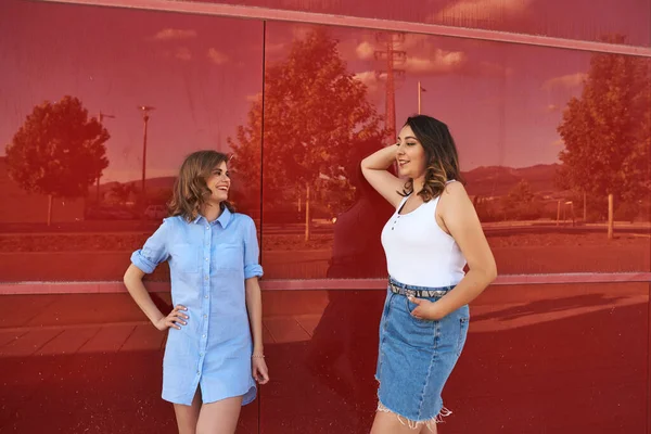 Duas Mulheres Posando Fundo Vermelho Estão Livre Numa Cidade — Fotografia de Stock