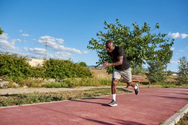 Güneşli bir yaz gününde koşan Afrikalı bir sporcu. Resimdeki metin için boşluk.