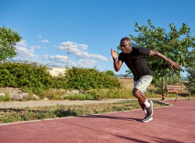 Güneşli bir yaz gününde koşan Afrikalı bir sporcu. Resimdeki metin için boşluk.