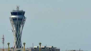 Barselona Uluslararası Havaalanı radar trafik kontrol kulesi. Gökyüzünde uçan uçak ile Barselona havaalanında Hava trafik kontrol kulesi. Havaalanı kontrol kulesi tam kapasitede. Gökyüzünde bir uçak ile radar kontrol kulesi.