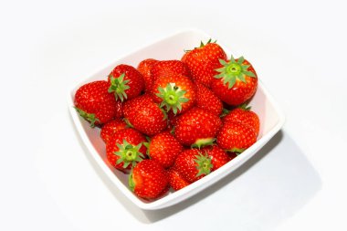 Tabakta çilek. Beyaz arka planda çilekler.