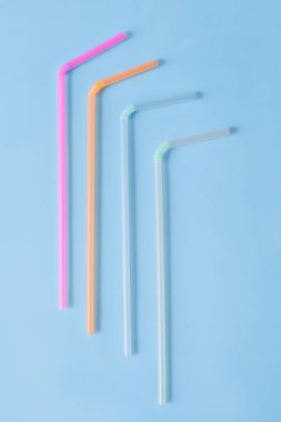 Mavi arka plandaki içecekler için çok renkli plastik borular..