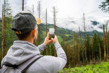 Bir adam dağlara seyahat eder. Yürüyüş. Yağmurlu bir günde yazın yüksek dağlar.
