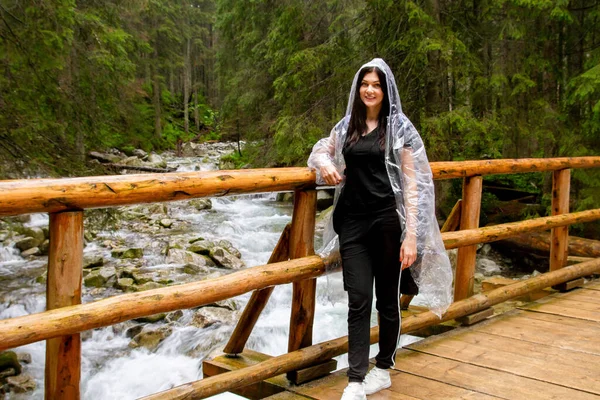 Kız dağlara seyahat ediyor. Yürüyüş. Yağmurlu bir günde yazın yüksek dağlar.