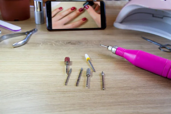 Manicure machine. Cutters for manicure. The girl holds in her hand.Manicure at home.