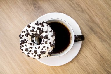 Beyaz şekerli ve siyah kırıntılı siyah çörek. Kahve ve sade kahve..