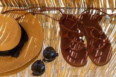 Yaz sandaletleri, güneş gözlükleri ve bir şapka..