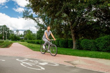 Bisiklet yolunda bisiklet süren bir adam.