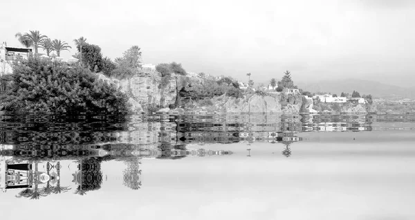 The beginning of the end,  climate change does not exist, phrase of D.Trump, dystopian photography black and white photograph of Nerja, Spain, flooded by the rising sea waters,