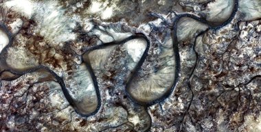 uzun ve eğri yol, Afrika çöllerinin havadan görünüşü, çöl manzaralarının havadan görünüşü, türü: soyut doğalcılık, mecazi, çağdaş fotoğraf, stok fotoğrafı,