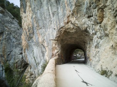 Tartales şelale alanının manzarası, ormanlar, dar yollar, kayalardaki tüneller, turizm beldesi, Burgos, Las Merindades, İspanya,