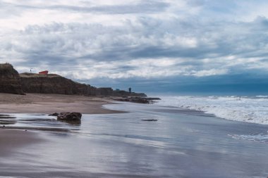 Kumsalda bulutlu bir gün Deniz kenarında Evler uzakta