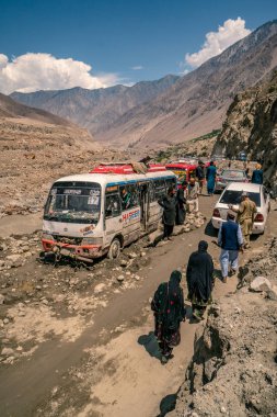 Karakoram Highway, Pakistan - July 19, 2018: Buses stuck in mud after massive landslide on Karakoram Highway in Pakistan. Illustrative editorial. clipart