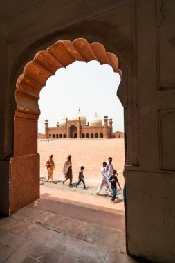 Lahor, Pakistan - 5 Ağustos 2018: Pakistan 'ın Lahor kentindeki Badshahi Camii önünde yürüyen turistler. İllüstrasyon Editörü.