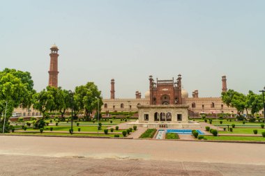 Badshahi Mosque with beautiful green gardens  in Lahore, Pakistan. Popular tourist attraction. clipart