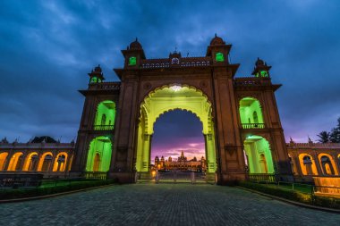 Beautiful historical gate in Mysore, Karnataka, India in late evening lit by colorful lights. clipart