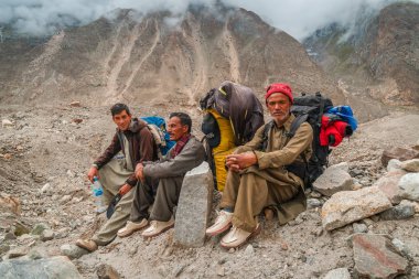 Karakoram, Pakistan - 24 Temmuz 2018: Şerpalar Pakistan 'daki Karakoram Dağları' ndaki K2 ana kampına giderken dinleniyor. İllüstrasyon Editörü.