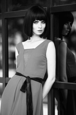 Son moda saç kesimi. Güzel yakın çekim portre toyng kadın moda küpe ve uzun drees retro vintage tarzı. Parlak renkli makyaj ve stilysh saç kesimi. Dış sokak fotoğraf. Siyah ve beyaz.