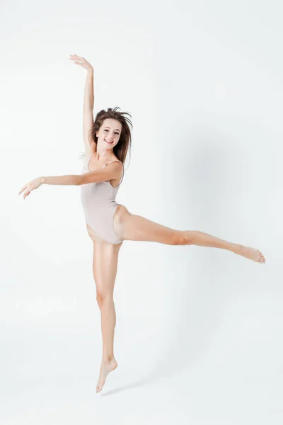 完璧なスリムな体と長い脚と美しい女性ジャンプ フィットネスの概念 白い背景の上の幸せと笑顔の若い女の子 — ストック写真