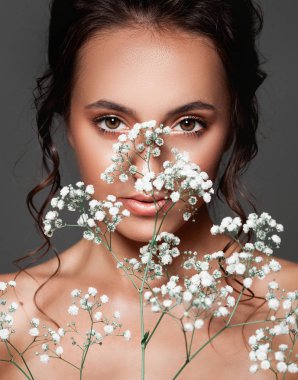 Taze temiz ten elini üzerinde beyaz çiçekli olan güzel kadın. Tedavi ve güzellik kavramı.