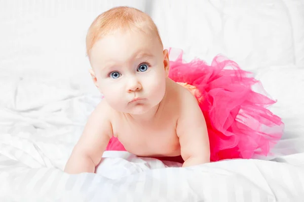 Aranyos Baba Lány Rózsaszín Szoknya Fehér Takaró Alatt Kék Szemmel — Stock Fotó