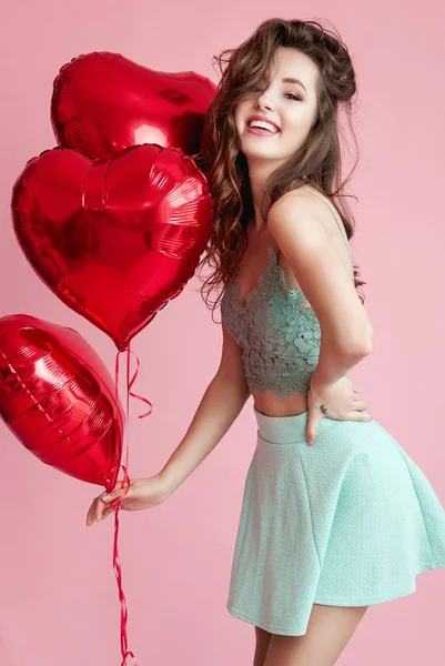 愉快美丽的年轻妇女与红色的气球在粉红色的背景 情人节或妇女日 — 图库照片