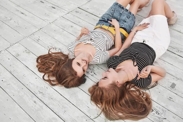 Dos jóvenes guapas divirtiéndose, sonriendo y riendo en el wo — Foto de Stock