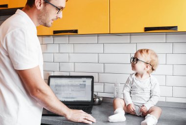 Aile babası internet üzerinden bir dizüstü bilgisayar ile çalışıyor, telefon konuşurken