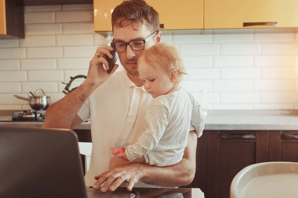 Счастливый молодой отец работает на ноутбуке дома с маленьким ребенком да — стоковое фото