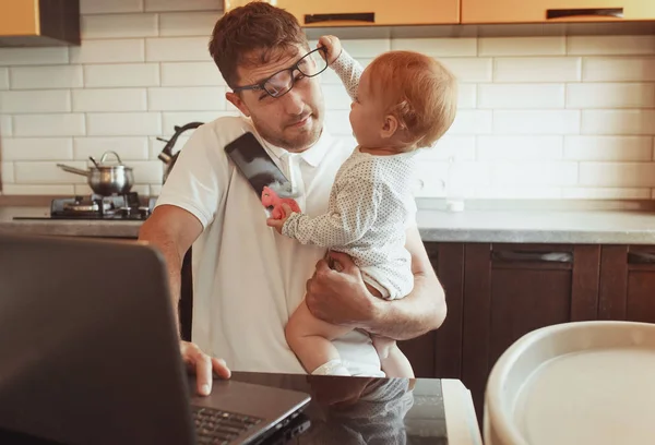 Multitâche Père travaillant de la maison sur ordinateur portable avec bébé daught — Photo