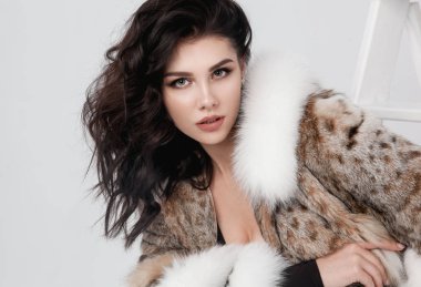 Lüks bir kürk manto giymiş zarif bir kadın.