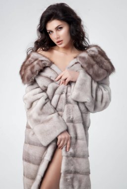 Lüks bir kürk manto giymiş zarif bir kadın.