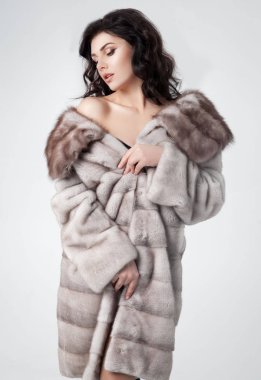 Lüks bir kürk manto giymiş zarif bir kadın.