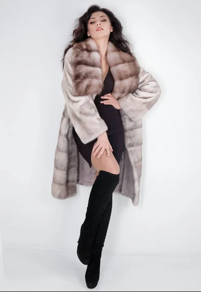 Krásná elegantní žena pózující v luxusní módní kožich přes w — Stock fotografie