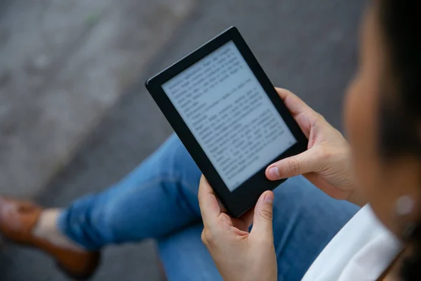 Genç Latin kadın dijital tablet cihazıyla kitap okuyor. Kitaba odaklan..