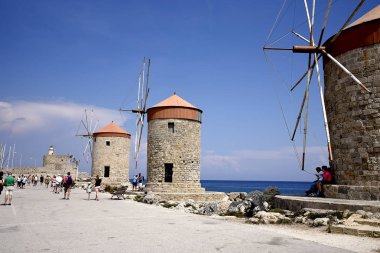Mandraki Limanı Yunan Adası Rhodes.Three yel değirmenleri ve St Nikolas fort üzerinde durmak Harbour duvar ve Governors Palace bir tarafında ve kilise varsayım diğer stand. Derin deniz Limanı yolcu gemilerine için yakındadır