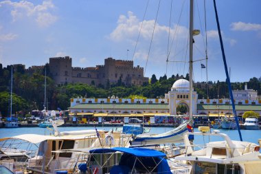 Mandraki Limanı Yunan Adası Rhodes.Three yel değirmenleri ve St Nikolas fort üzerinde durmak Harbour duvar ve Governors Palace bir tarafında ve kilise varsayım diğer stand. Derin deniz Limanı yolcu gemilerine için yakındadır