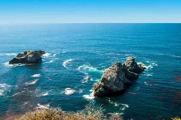 The wild and beautiful Pacific Coast between Mexico and Canada in the USA. Bordered to the east by the  Mountains and the west by the Pacific Ocean. The road is known for winding turns, wild waves,seaside cliffs and views of the often-misty coastline