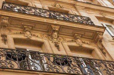 Üzerinde balkon ve saat olan bir bina.