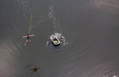 Ivanovsky Köprüsü, Ukrayna - 21 Haziran 2020: Kayıklı bir adam köprüden atladıktan sonra ipte sallanan bir adamı yakalamaya çalışıyor. Ekstrem Spor ve Eğlence Konsepti.