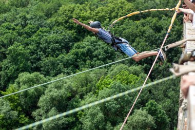Ivanovsky Köprüsü, Ukrayna - 21 Haziran 2020: Ekstrem Spor ve Eğlence kavramı. Bir adam köprüden ip atlama yapıyor. O, bir rüyayı gerçekleştirmekten mutlu. Tüm ekipmanlar çok sağlam.