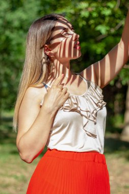 Palmiye yaprağının arka planında çok güzel bir manikür. Bir parmağında karpuz resmi var, diğer parmaklarının hepsi pembe.