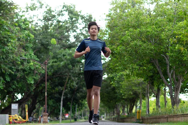 asian young fitness man runner running at the park