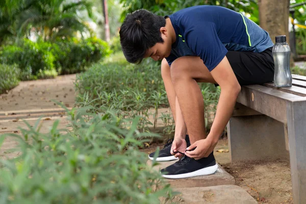 Azji Młody Fitness Człowiek Biegacz Siedzieć Krzesło Park Wiązanie Buty — Zdjęcie stockowe
